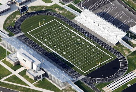 Aerial view showcasing a football field surrounded by a stadium