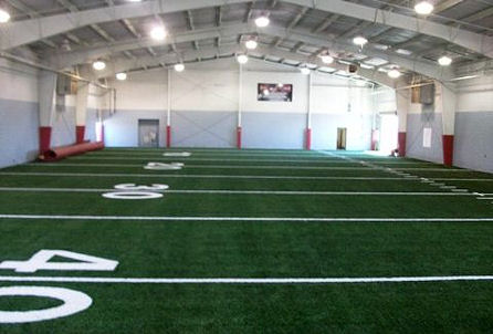 A spacious indoor football field featuring a prominent number displayed on the surface.